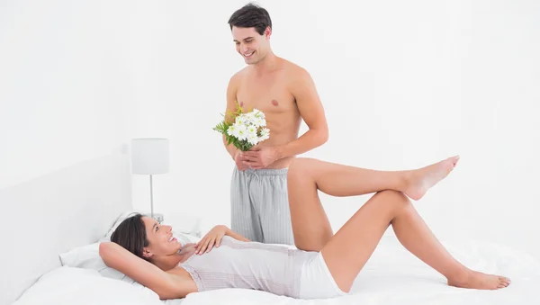 Shirtless man offering flowers — Stock Photo, Image