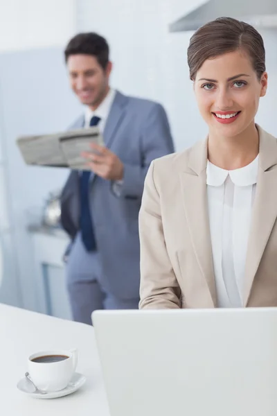 Empresária usando um laptop antes de ir trabalhar — Fotografia de Stock