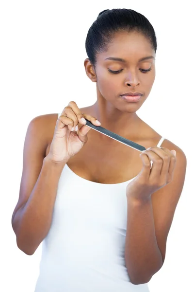 Serious young woman using nail file — Stock Photo, Image