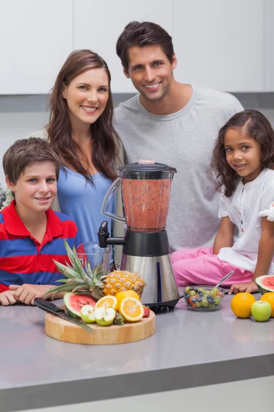 Família sorrindo usando um liquidificador juntos — Fotografia de Stock