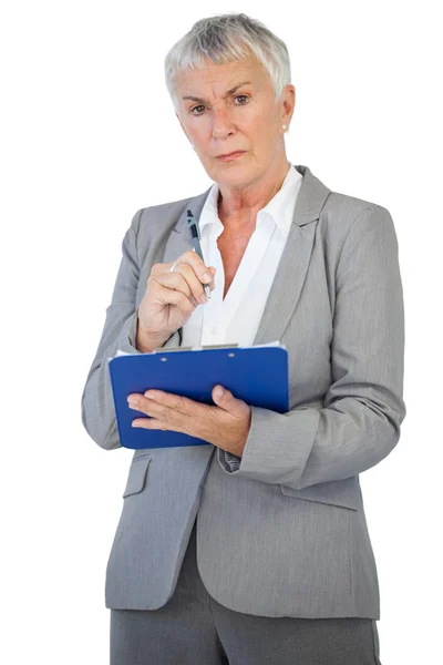 Mujer de negocios seria sosteniendo su portapapeles — Foto de Stock