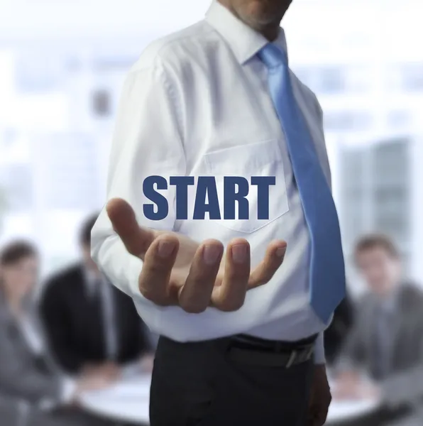 Elegant businessman holding the word start — Stock Photo, Image