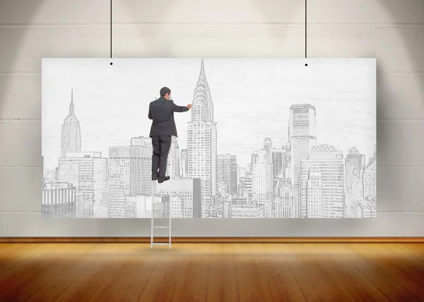 Geschäftsmann steht auf Leiter und zeichnet eine Stadt auf ein Plakat hu — Stockfoto