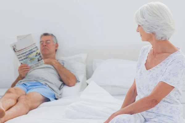 Woman looking at husband in the bed — Stock Photo, Image