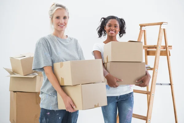 Happy housemates carrying moving boxes — Stock Photo, Image