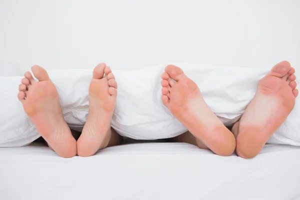 Pieds d'un couple au lit — Photo