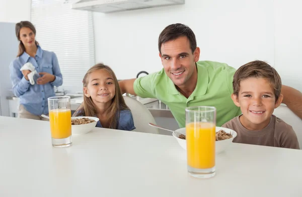 Porträt eines Vaters und seiner Kinder beim Frühstück — Stockfoto