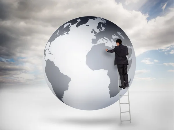 Businessman on a ladder drawing on a planet — Stock Photo, Image