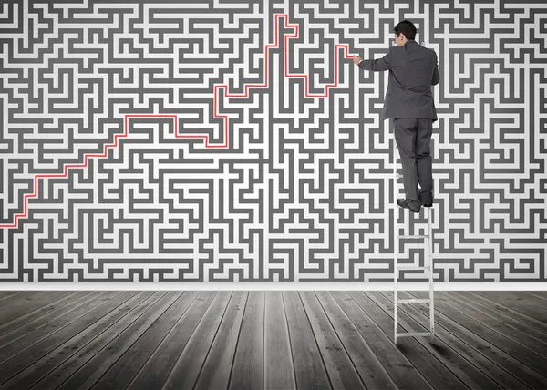 Homme d'affaires debout sur une échelle résoudre labyrinthe puzzle — Photo