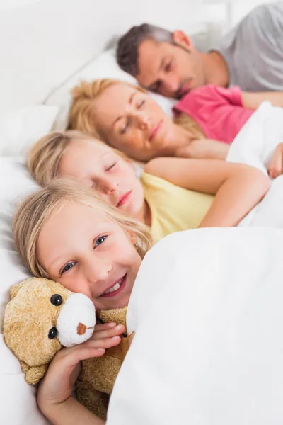 Young girl awake next to her sleeping family — Stock Photo, Image