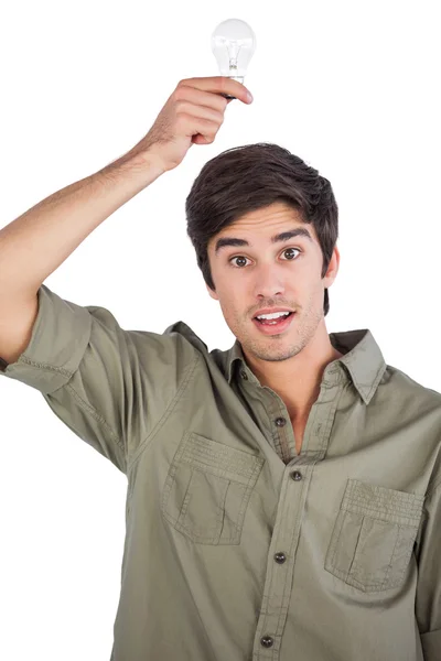 Surprised man holding light bulb above his head — Stock Photo, Image