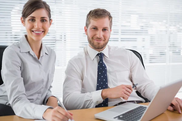 Mensen uit het bedrijfsleven glimlachen op camera met laptop — Stockfoto