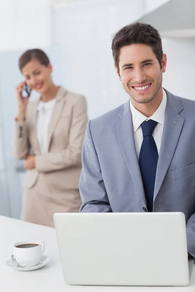 Empresário feliz usando um laptop antes de ir trabalhar — Fotografia de Stock