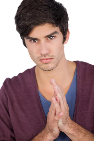 Upset young man with hands together — Stock Photo, Image