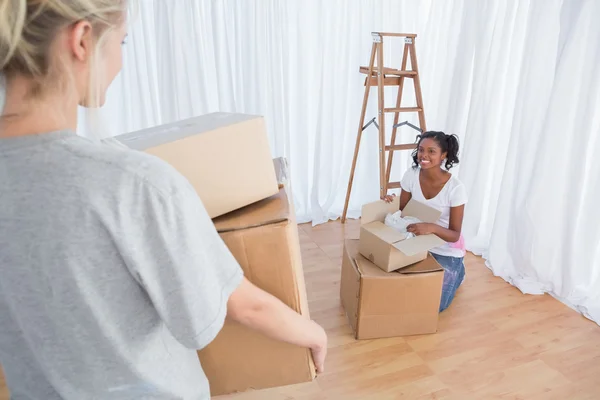 Amigos felices desempacando en su nuevo hogar — Foto de Stock