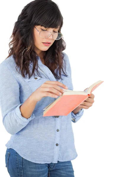 Brunette dragen van een bril en het lezen van haar boek — Stockfoto