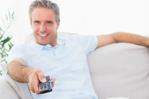 Feliz hombre en su sofá viendo la televisión — Foto de Stock