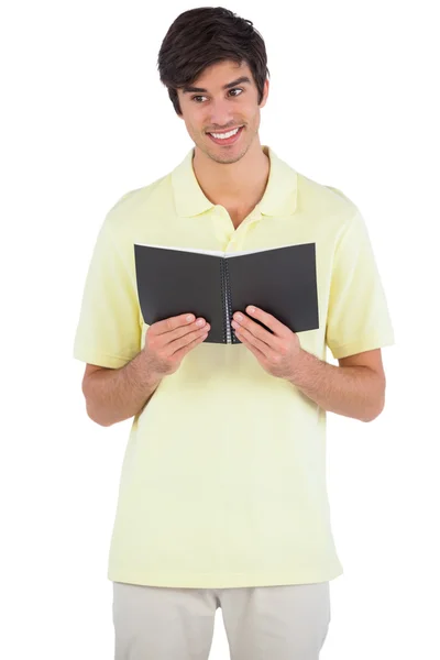 Studente sorridente che tiene un quaderno — Foto Stock