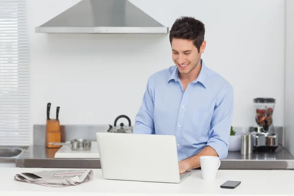 Mann benutzt Laptop in der Küche — Stockfoto