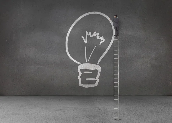 Businessman drawing a light bulb — Stock Photo, Image