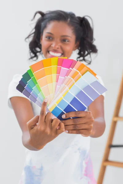 Excited woman showing colour charts and pointing — Stock Photo, Image