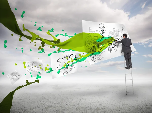 Empresario dibujando en un papel junto a salpicaduras de pintura verde — Foto de Stock