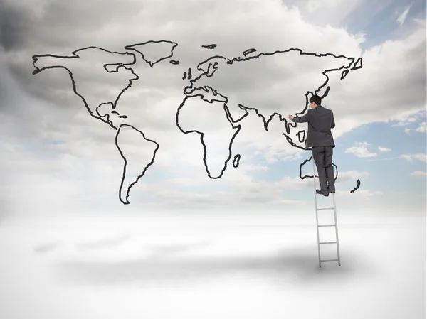 Businessman on a ladder drawing a world map — Stock Photo, Image