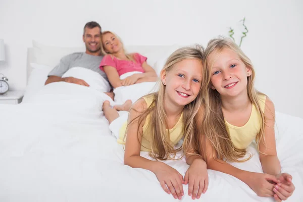 Zwillinge posieren im Bett vor ihren Eltern — Stockfoto