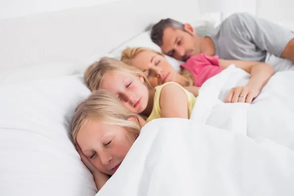 Pais dormindo com seus filhos na cama — Fotografia de Stock