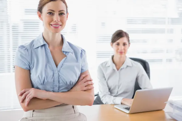 Gelukkig zakenvrouwen glimlachen op camera op hun bureau — Stockfoto