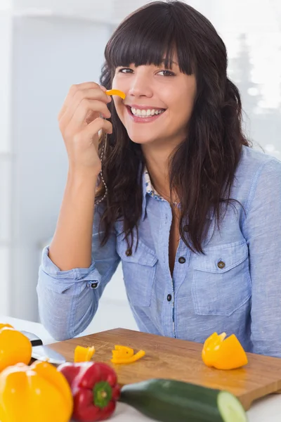 Bonita morena segurando pedaço de pimenta — Fotografia de Stock