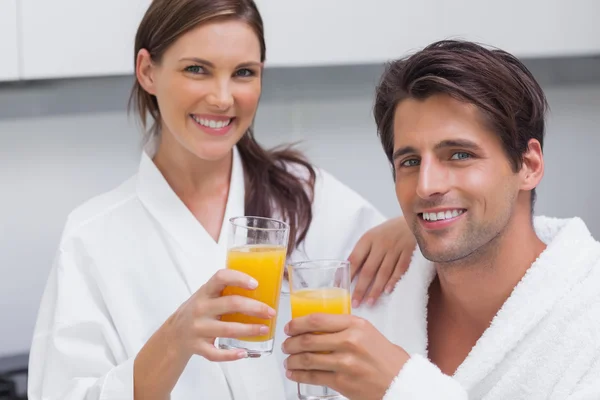 Par hålla glas apelsinjuice — Stockfoto