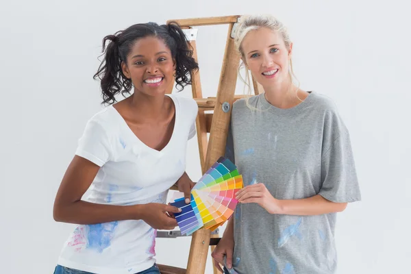 Дружелюбные домохозяйки выбирают цвет для стены, глядя в камеру — стоковое фото