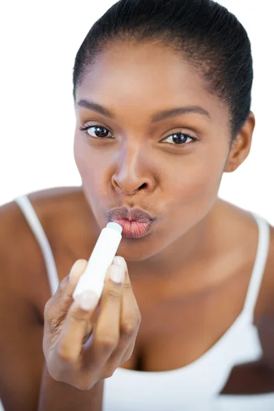 Junge Frau setzt Lippenbalsam auf ihre Lippen — Stockfoto