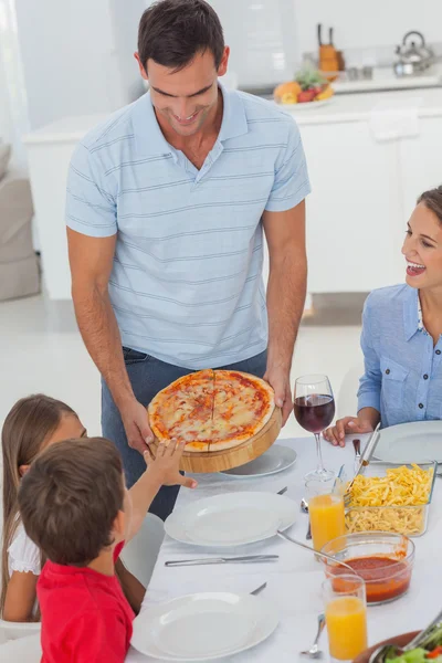 Un bel homme apporte une pizza à sa famille — Photo