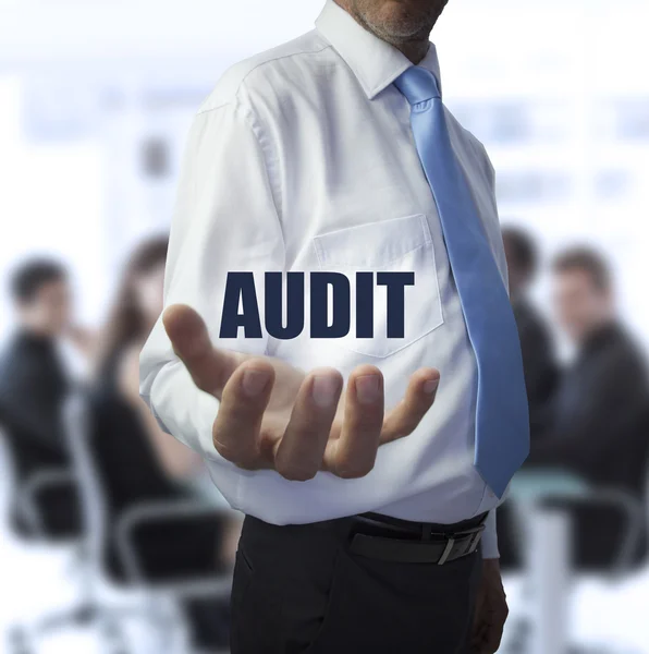 Smart businessman holding the word audit — Stock Photo, Image