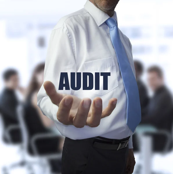 Homme d'affaires intelligent tenant le mot audit — Photo