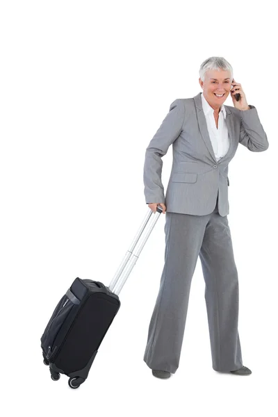 Smiling businesswoman with her luggage and calling someone — Stock Photo, Image