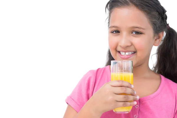 Fröhliches kleines Mädchen trinkt Orangensaft — Stockfoto