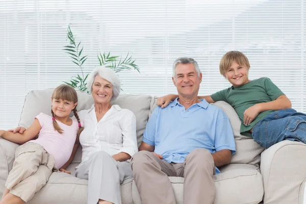 Far-och morföräldrar och barnbarn sitter på soffan — Stockfoto