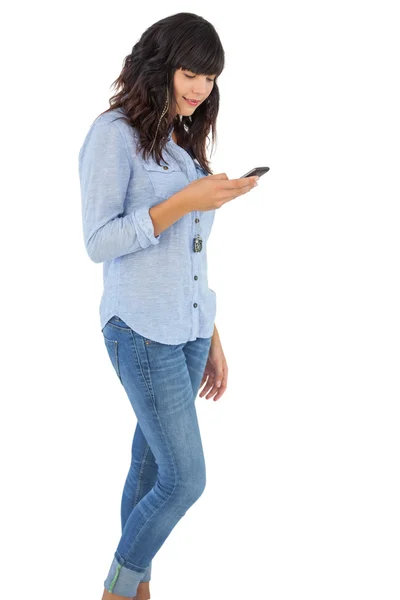 Brunette met haar mobiele telefoon SMS een bericht — Stockfoto