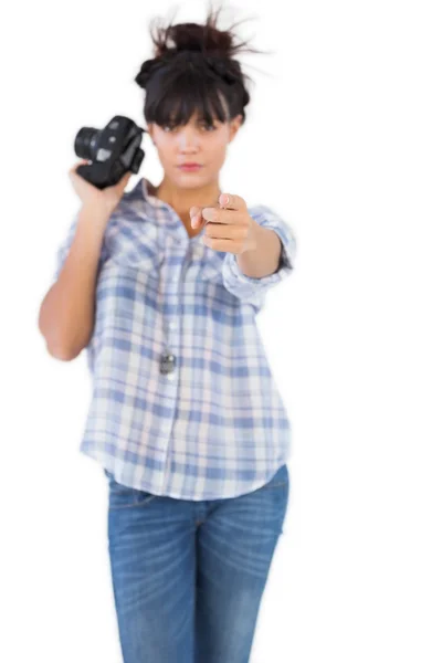 Mujer seria sosteniendo la cámara y señalando con el dedo — Foto de Stock