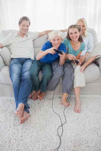 Crianças jogando videogames juntas sentadas no sofá — Fotografia de Stock