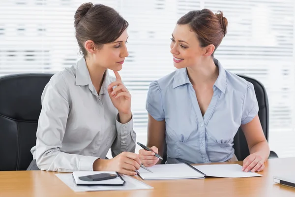 Lächelnde Geschäftsfrauen, die gemeinsam an Dokumenten arbeiten — Stockfoto