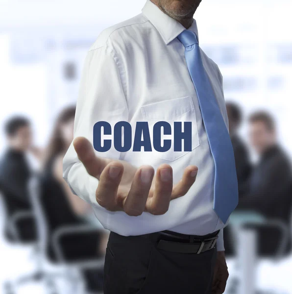 Elegant businessman holding the word coach — Stock Photo, Image