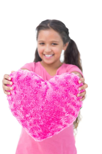 Маленькая девочка показывает подушку в форме сердца — стоковое фото