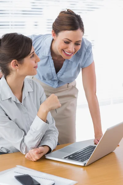 Smiling businesswomen working together with laptop — Stock Photo, Image
