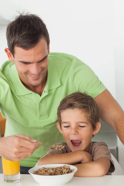 Father giving cereal to his son — Stock Photo, Image