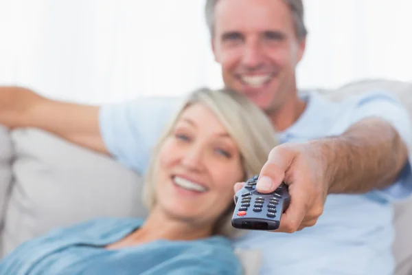 Feliz pareja relajándose en casa viendo la televisión —  Fotos de Stock