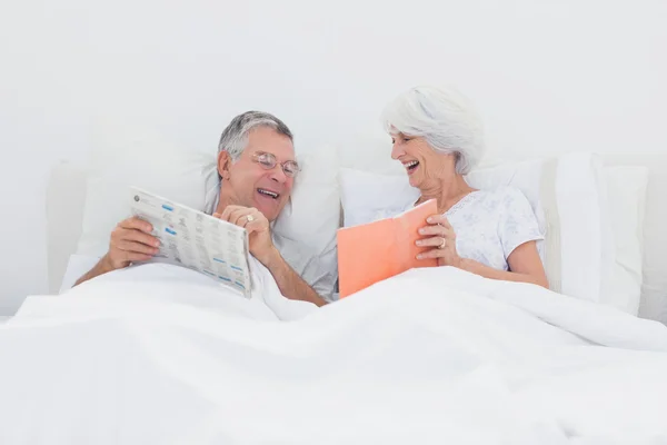 Fröhliche Frau zeigt Ehemann ihr Buch — Stockfoto